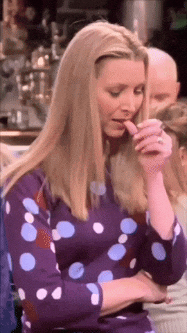 a woman in a purple and blue polka dot dress holds her hand to her mouth