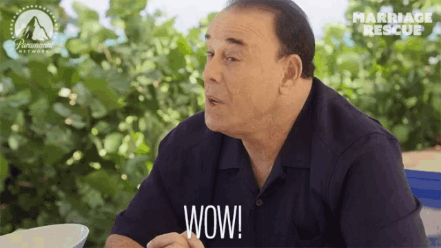 a man sitting at a table with a paramount network logo behind him