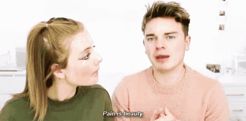 a man and a woman are sitting next to each other and the woman is saying pain is beauty .