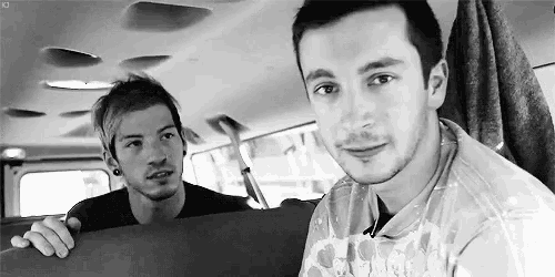 a black and white photo of two men sitting in a van .