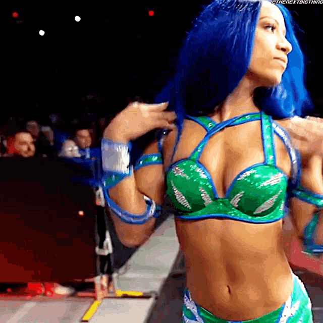 a woman with blue hair is wearing a green bra