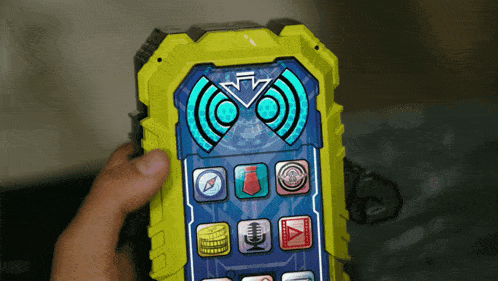 a person is holding a toy phone that has a compass and a microphone on it