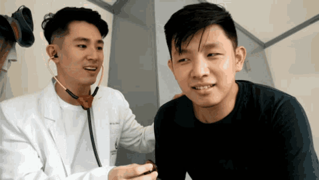a man with a stethoscope around his neck talks to another man