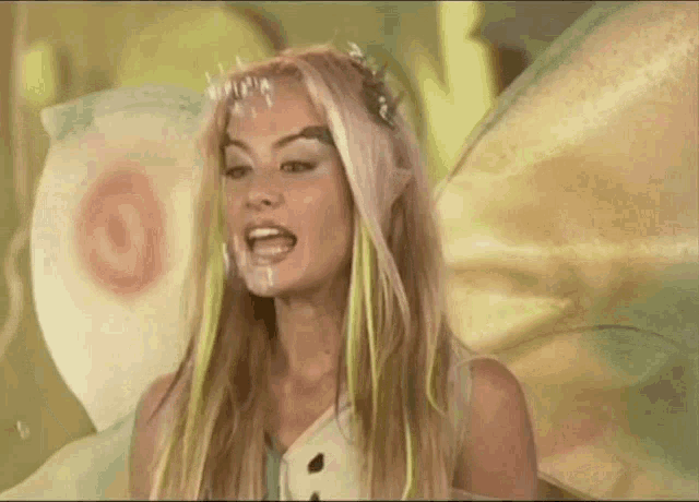 a woman is dressed as a fairy with a butterfly wing on her head