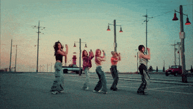 a group of women are dancing on the street
