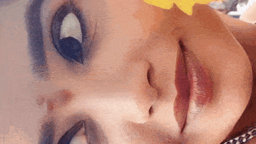 a close up of a woman 's face with a flower in her nose .