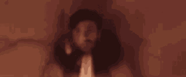 a blurry picture of a man holding a torch in his hand .