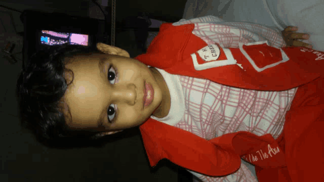 a little boy wearing a red jacket that says " i love you " on it