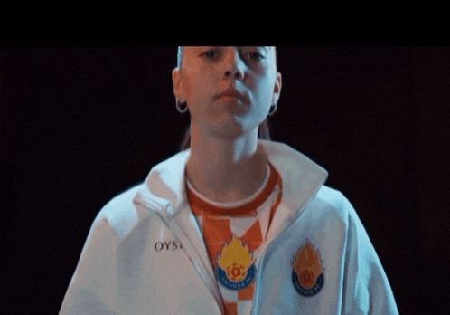 a woman wearing a white jacket that says oysi on it