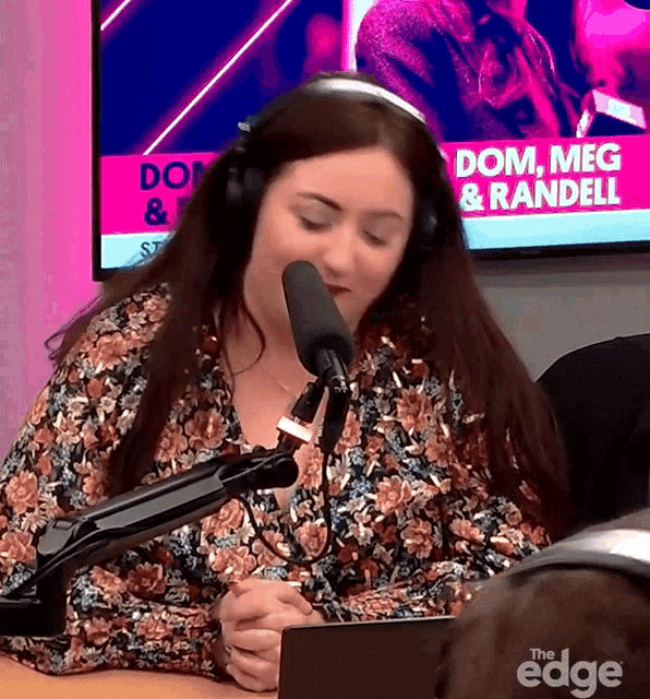 a woman wearing headphones is sitting in front of a microphone in front of a screen that says dom meg & randell