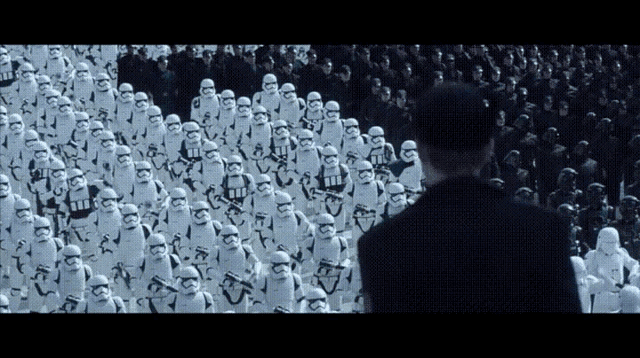 a man in a black hat stands in front of a large crowd of stormtroopers