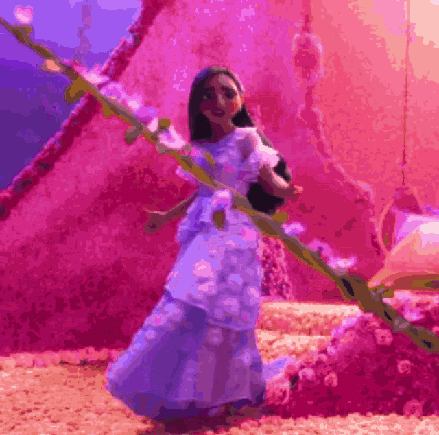 a doll in a white dress is standing in front of a pink wall holding a branch .