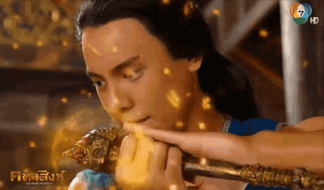 a close up of a man holding a sword with the number 7 in the corner