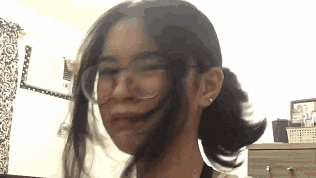 a woman wearing glasses is making a funny face .