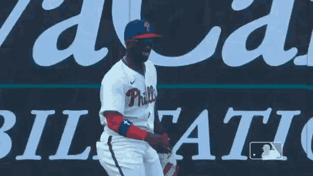 a baseball player is kneeling down in front of a sign that says athletic