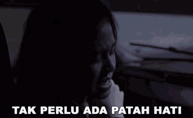 a woman sitting in a car with the words tak perlu ada patah hati written below her
