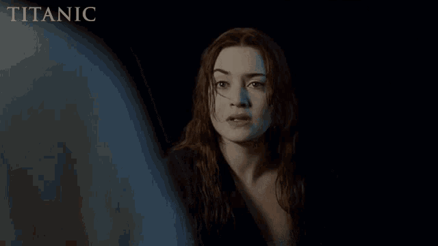 a woman in a dark room with the word titanic in the corner