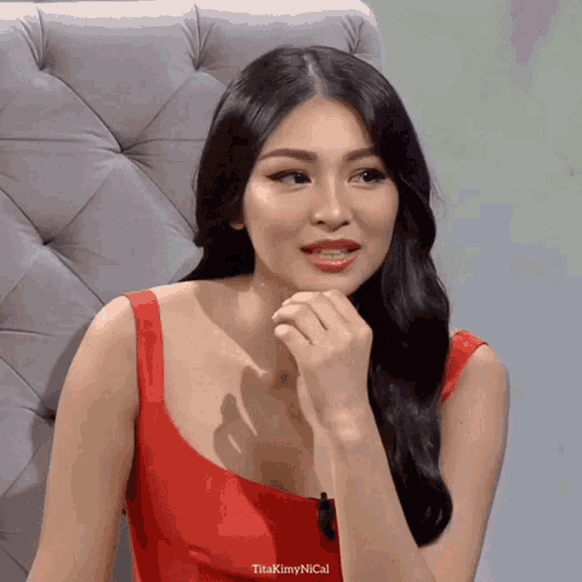 a woman in a red dress is sitting in a chair with the caption titakim ynical