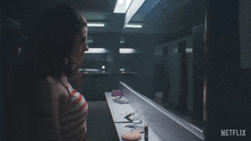 a woman is looking at herself in a mirror with netflix written on the bottom