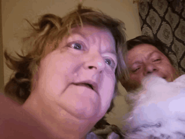 a man and a woman are eating cotton candy and making a funny face