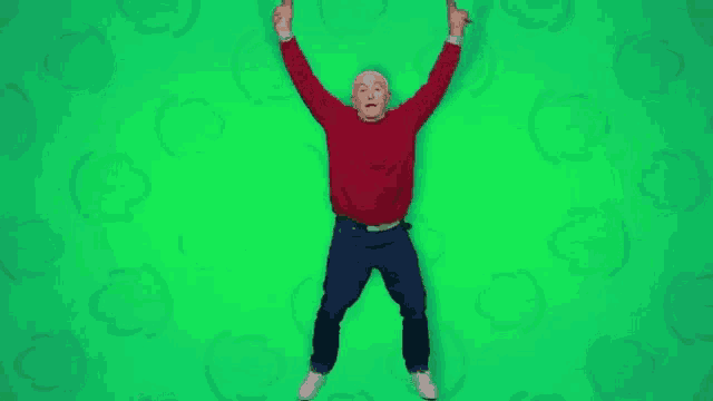a man in a red sweater and blue jeans is jumping in the air