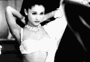 a black and white photo of a woman in a bra .