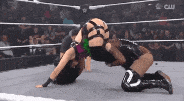 two women are wrestling in a ring with the words cw on the bottom
