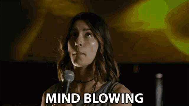 a woman stands in front of a microphone with the words mind blowing written below her