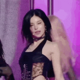 a close up of a woman wearing a choker and a black top dancing on a stage .