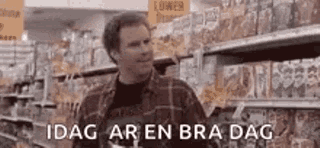 a man in a plaid shirt is standing in front of a grocery store aisle .