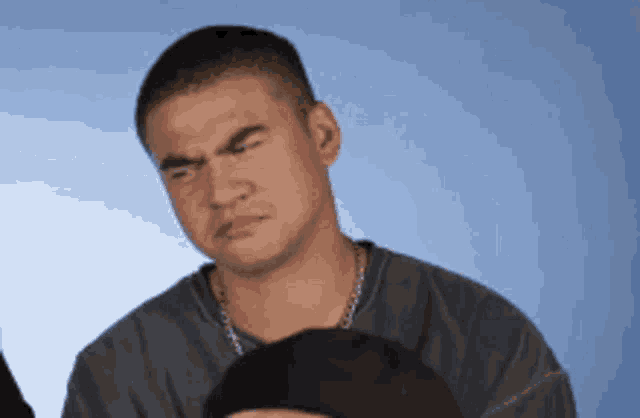 a man is making a funny face while wearing a hat