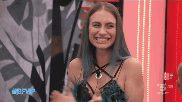 a woman with blue hair is smiling with the hashtag #gfvip on the bottom