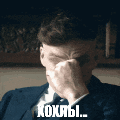 a man in a suit and tie is covering his face with his hand and the words xoxlbi written below him
