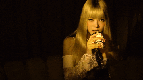 a woman with blonde hair is singing into a microphone that says ' nm ' on it