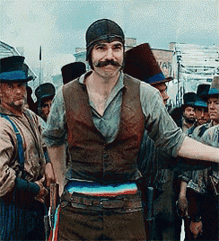 a man with a mustache is standing in front of a group of men