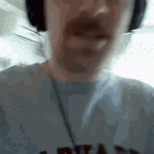 a man with a beard wearing headphones and a shirt that says ' ryan ' on it .