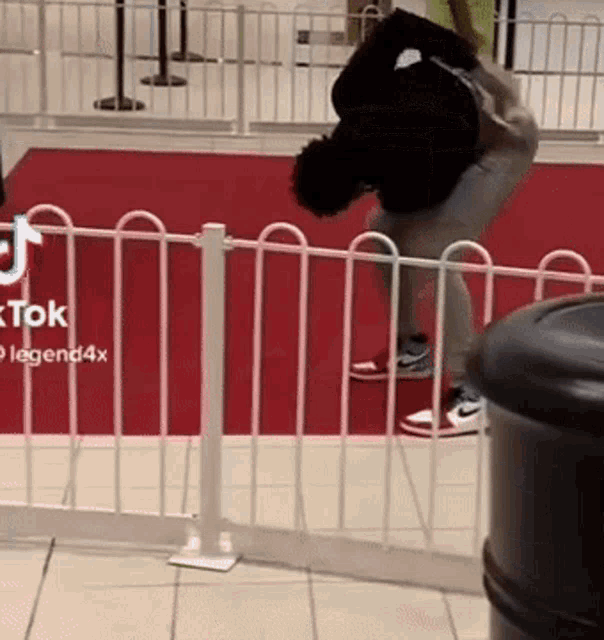 a man is doing a trick on a red carpet in front of a fence with tiktok legend4x written on it