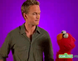 a man is flexing his muscles next to an elmo doll from sesame street