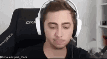 a man wearing headphones is sitting in a chair and making a funny face .