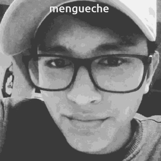 a man wearing glasses and a baseball cap has the word mengueche above his face