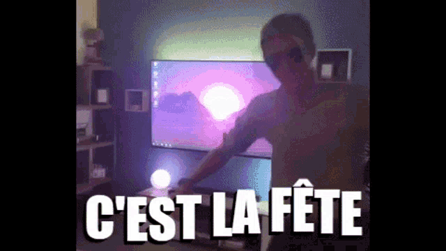 a man without a shirt is dancing in front of a television with the words c ' est la fete on the bottom
