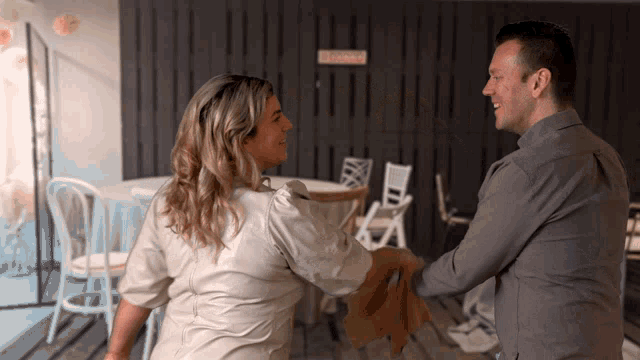 a man and a woman are dancing in front of a sign that says children