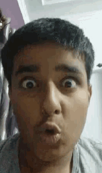 a man is making a funny face with his mouth open and his eyes wide open .