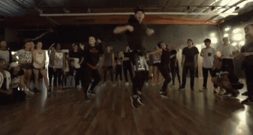 a group of people are dancing in a dance studio and one of them is wearing a shirt that says ' i love you '
