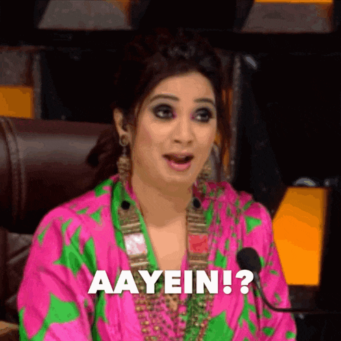 a woman in a pink and green dress says aayein ?