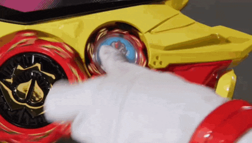 a person is pressing a button on a toy car with a white glove .