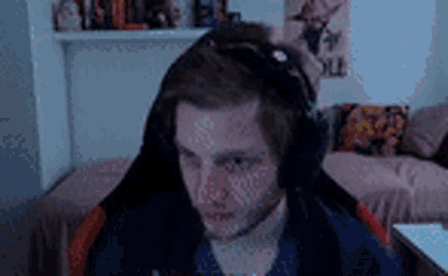 a man wearing headphones is sitting in a chair in front of a computer .