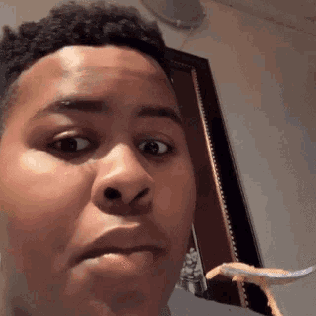 a man is holding a fork in his mouth and making a funny face