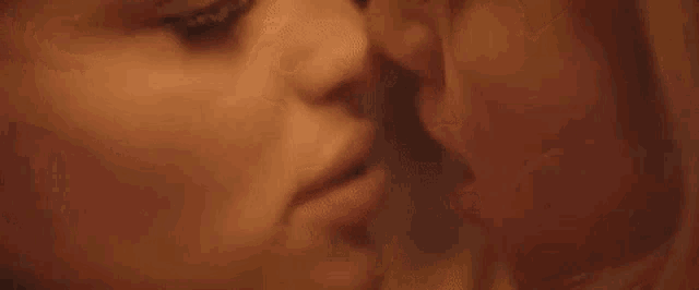 a close up of two women looking at each other 's faces