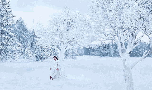 a man and a woman are standing next to each other in the snow and the woman is touching the man 's face